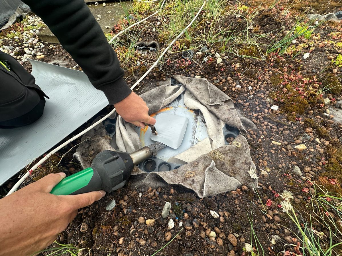 Navařování detailu u vpusti zelené střechy horkovzdušnou pistolí